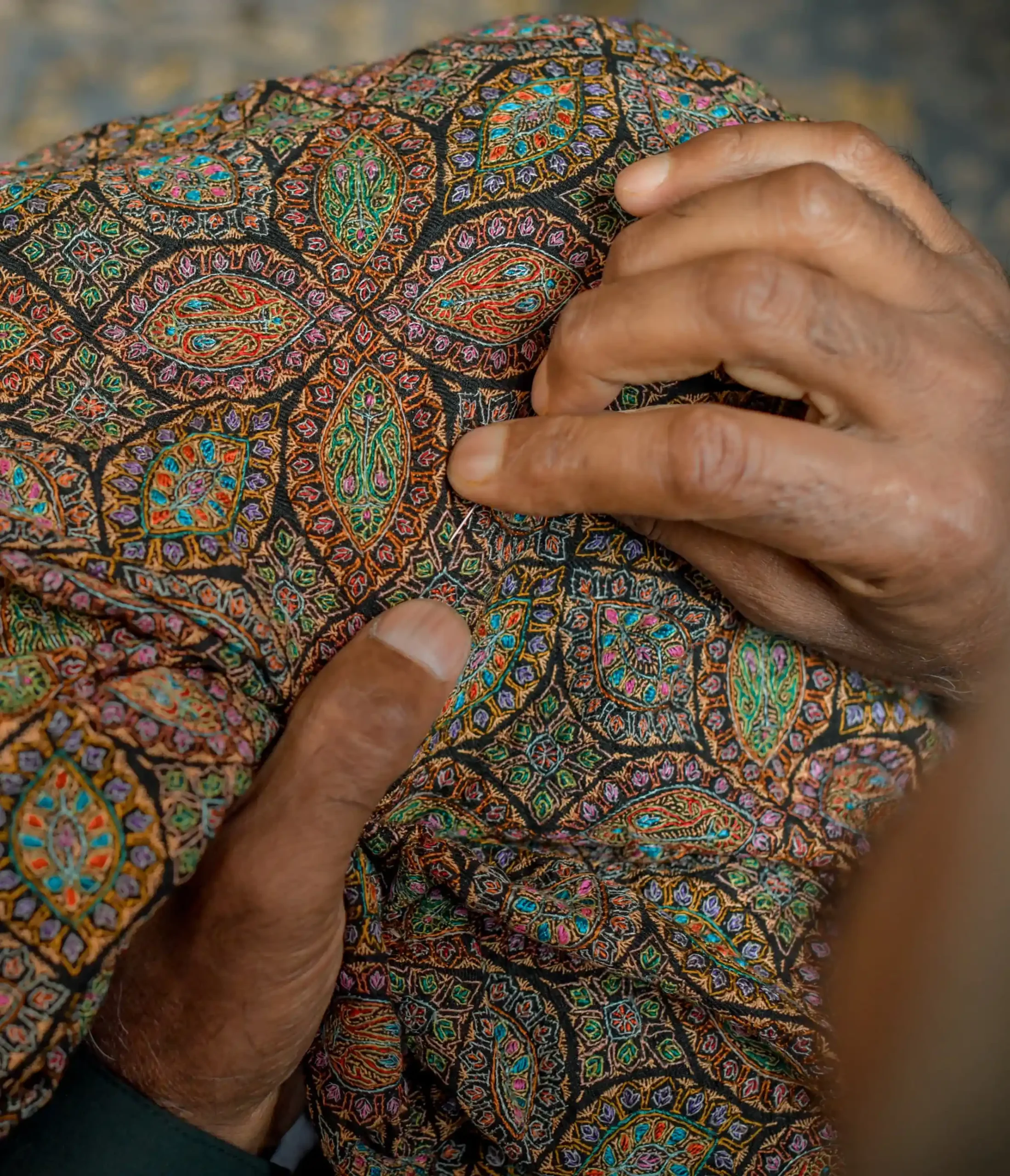 artisan doing sozni craft on pashmina shawl